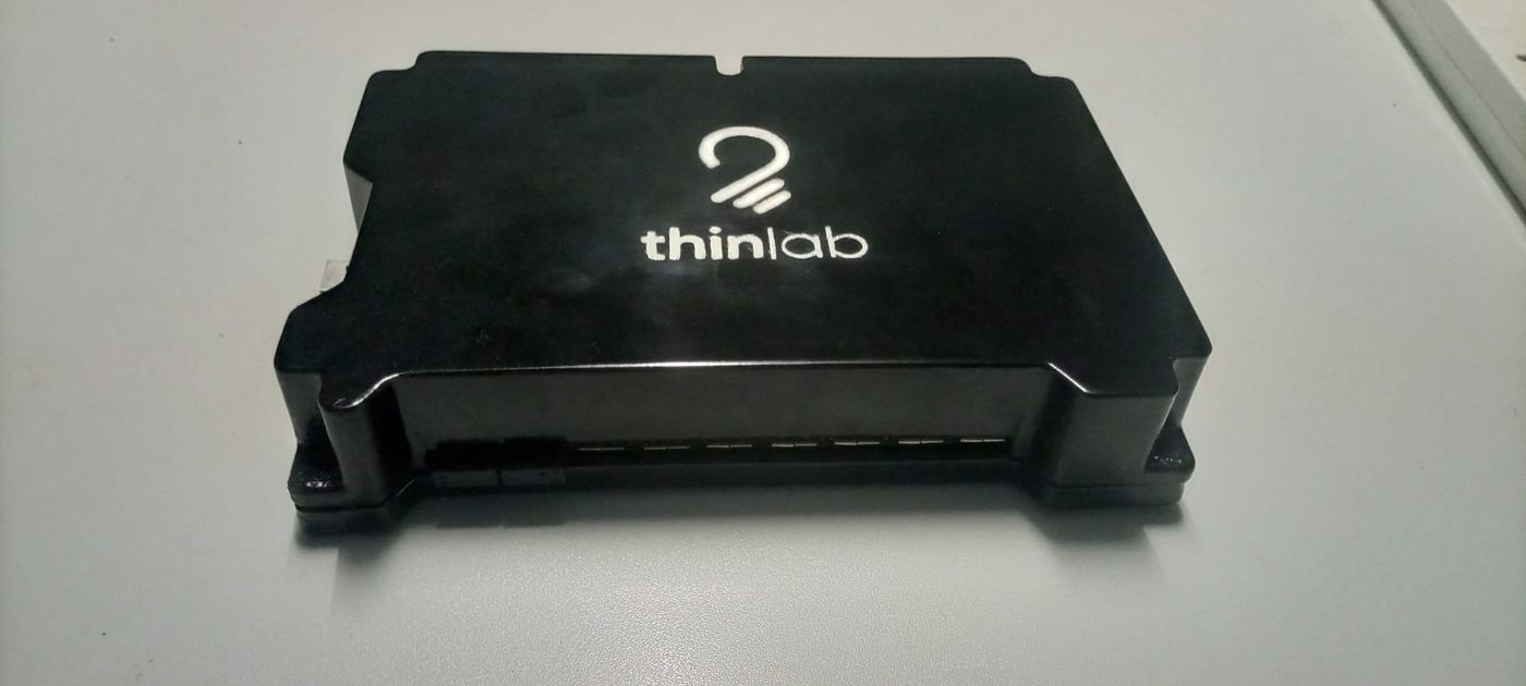 The ChungaBox device, a compact black control hub with the Thinlab logo, sitting on a desk.